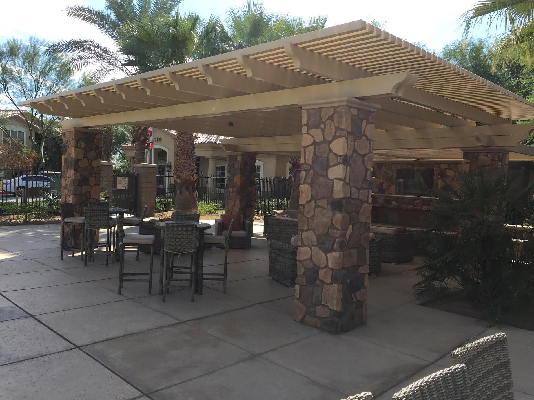 Solid Alumawood patio cover on stone columns over an outdoor living room